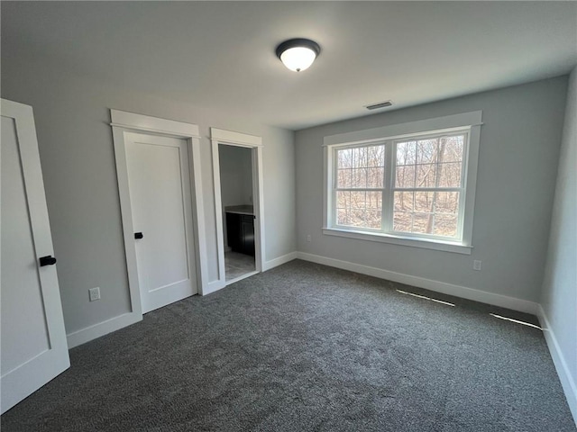 unfurnished bedroom with dark colored carpet