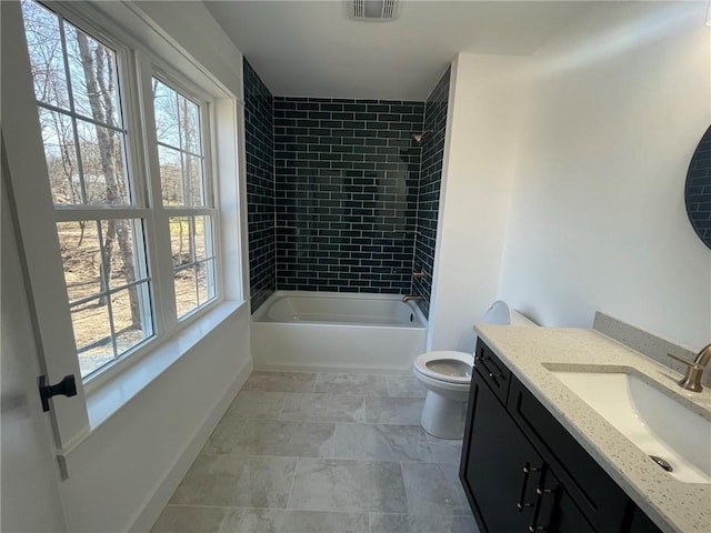 full bathroom with vanity, toilet, tiled shower / bath, and a wealth of natural light