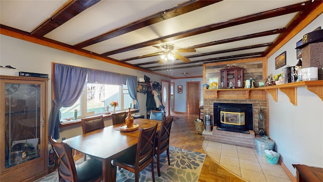 dining space featuring a wood stove, crown molding, ceiling fan, parquet flooring, and beamed ceiling