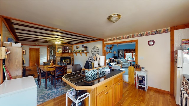 kitchen with a fireplace, ceiling fan, light hardwood / wood-style flooring, and white stove