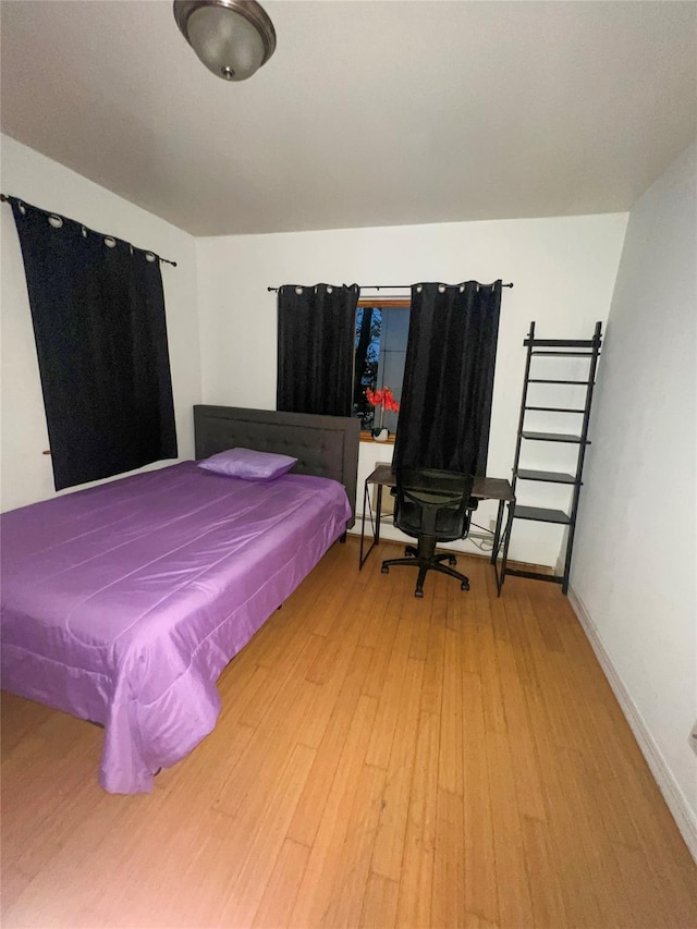 bedroom with light wood-type flooring and baseboards