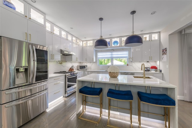 kitchen with sink, dark hardwood / wood-style flooring, a kitchen island with sink, white cabinets, and appliances with stainless steel finishes