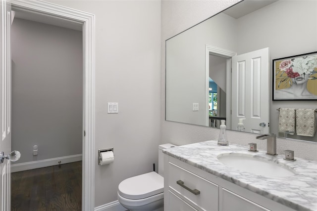 bathroom with hardwood / wood-style floors, vanity, and toilet