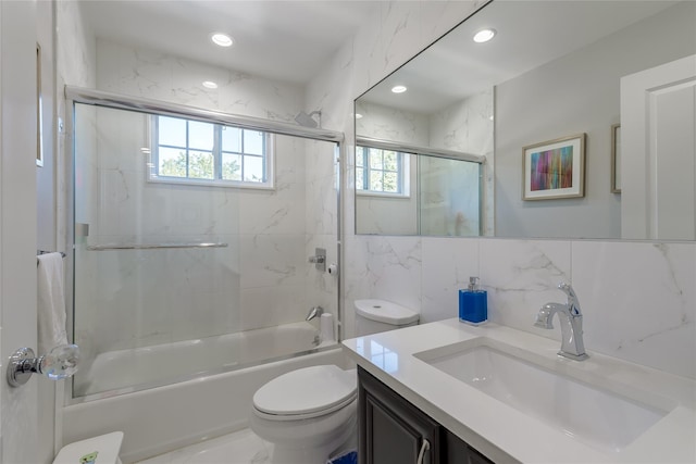 full bathroom featuring backsplash, bath / shower combo with glass door, toilet, vanity, and tile walls