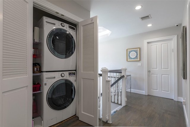 washroom with dark wood-type flooring and stacked washer / drying machine