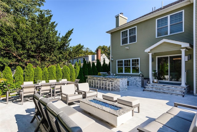 view of patio featuring an outdoor living space with a fire pit and exterior bar