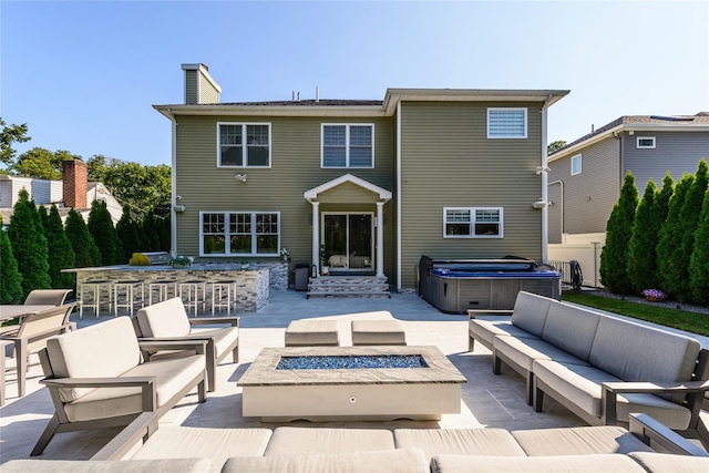 rear view of property featuring a patio area, a bar, and an outdoor living space with a fire pit