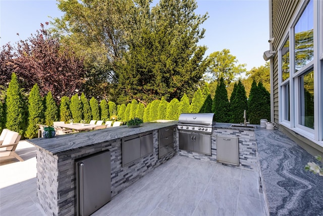 view of patio / terrace featuring a wet bar, area for grilling, and exterior kitchen