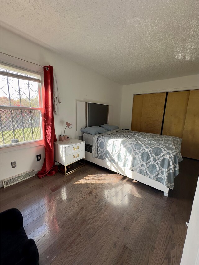 unfurnished bedroom featuring a textured ceiling and dark hardwood / wood-style floors