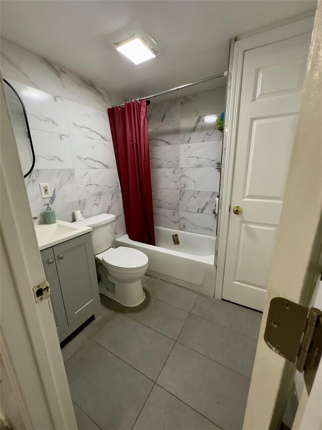 full bathroom featuring vanity, tile patterned flooring, toilet, shower / bath combo with shower curtain, and tile walls