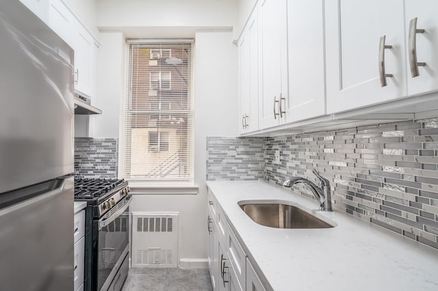 kitchen featuring sink, light stone counters, white cabinets, exhaust hood, and appliances with stainless steel finishes