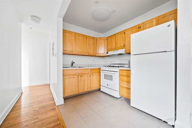 kitchen with light wood-type flooring, white appliances, sink, and range hood