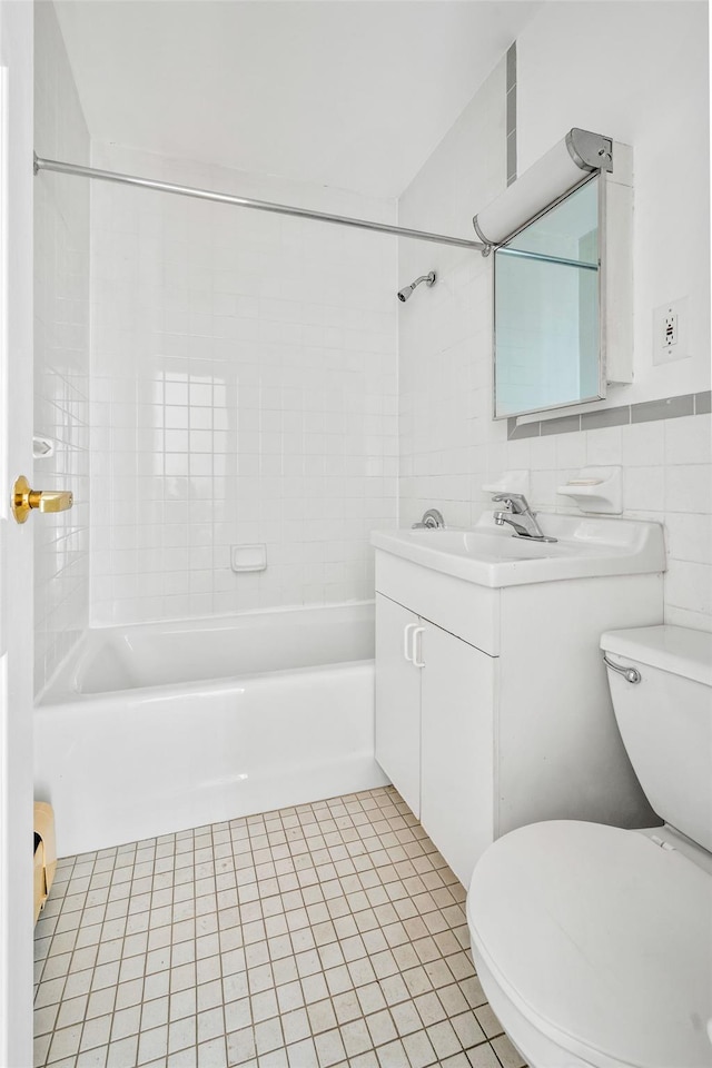 full bathroom with tile patterned floors, tiled shower / bath combo, toilet, and tile walls