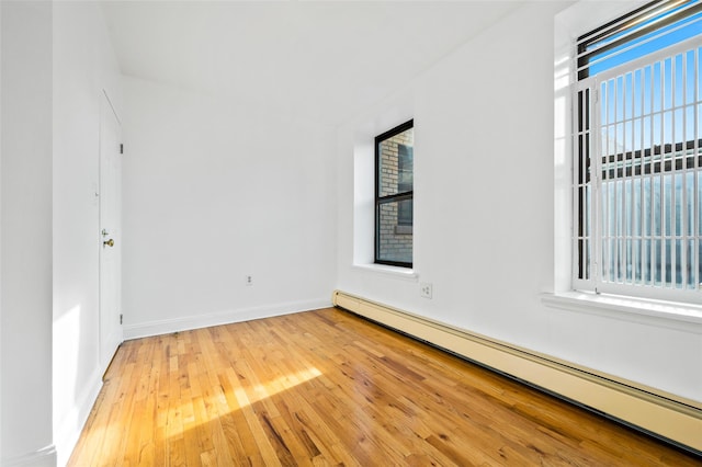 spare room featuring a baseboard radiator and hardwood / wood-style flooring