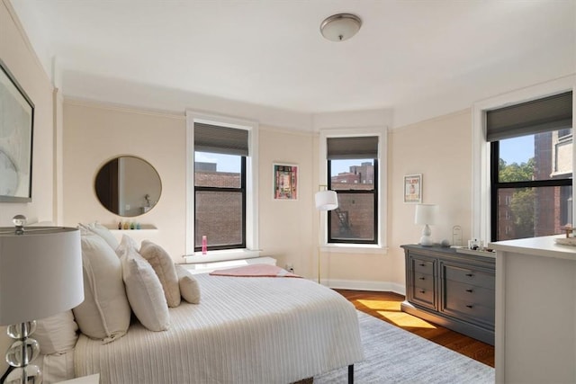 bedroom with light hardwood / wood-style floors and multiple windows