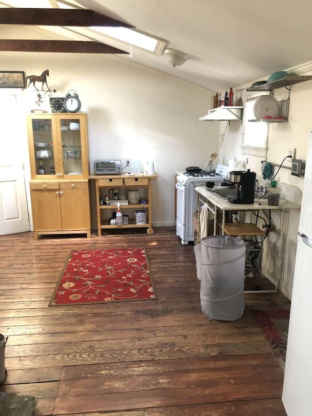 kitchen featuring white range with gas cooktop, dark wood-type flooring, and vaulted ceiling with skylight