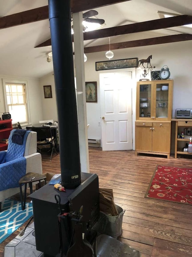 living room with a wood stove, wood-type flooring, and vaulted ceiling with beams