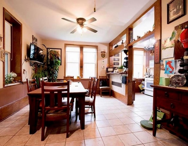 dining room featuring ceiling fan, light tile patterned floors, and a healthy amount of sunlight