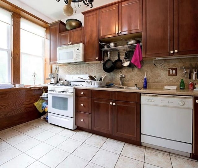 kitchen featuring decorative backsplash, white appliances, sink, and light tile patterned floors