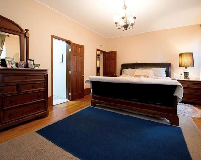 bedroom featuring light wood-type flooring and a notable chandelier