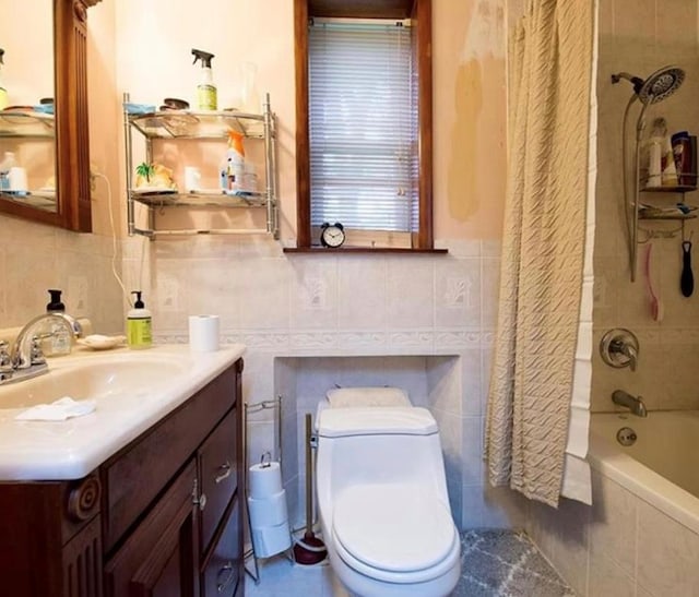 full bathroom featuring shower / bath combination with curtain, vanity, toilet, and tile walls