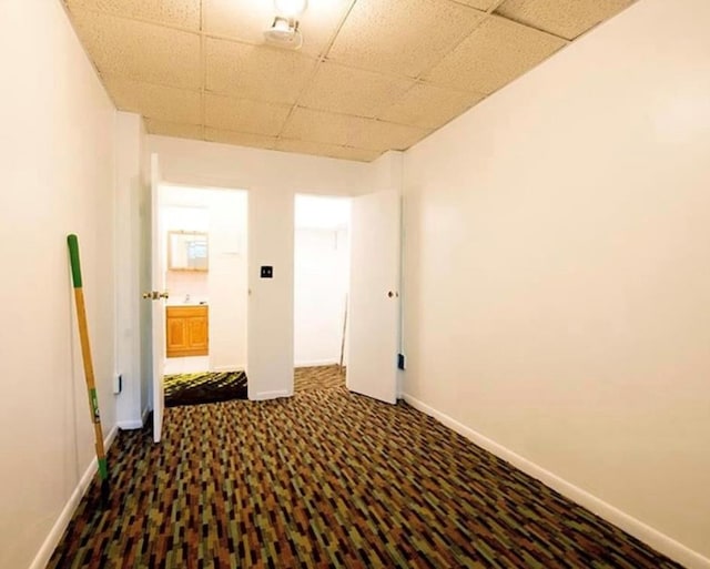 interior space with carpet flooring and a paneled ceiling