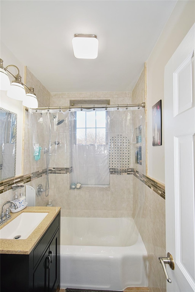 bathroom featuring vanity, tiled shower / bath, and tile walls