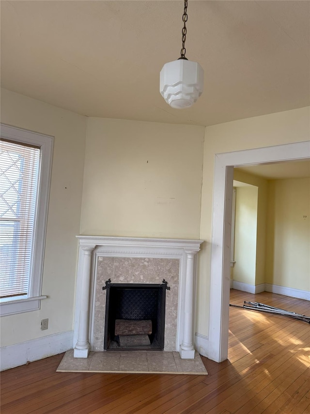 details with a tile fireplace and hardwood / wood-style flooring