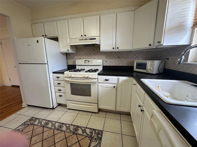 kitchen with white cabinetry, sink, light tile patterned floors, and white appliances