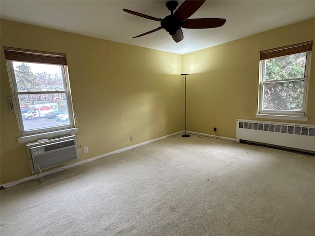 carpeted empty room with radiator, a wall mounted air conditioner, plenty of natural light, and ceiling fan