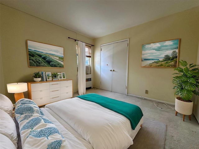 carpeted bedroom with radiator heating unit and a closet