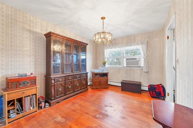 dining space with cooling unit, a notable chandelier, light hardwood / wood-style floors, and a baseboard heating unit