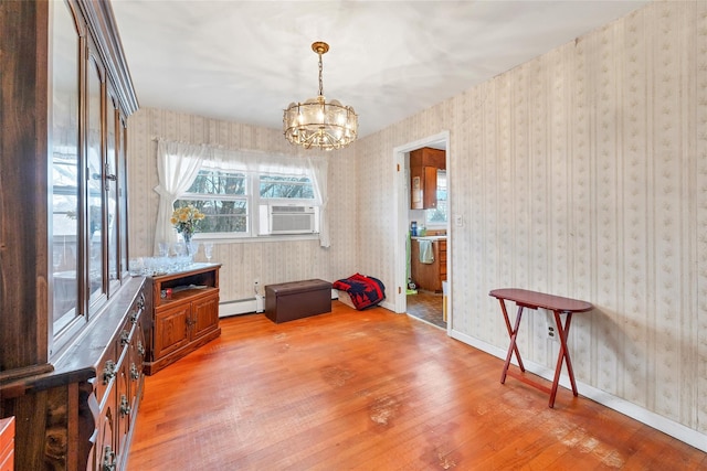 misc room with baseboard heating, light hardwood / wood-style flooring, cooling unit, and a chandelier