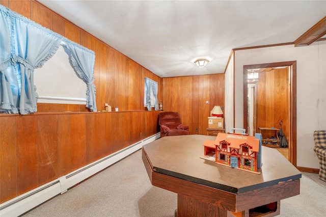 recreation room featuring light colored carpet, wooden walls, and a baseboard heating unit