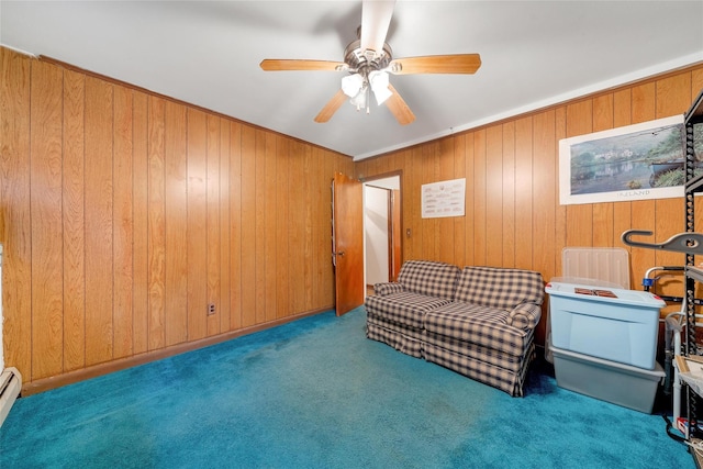 living area with ceiling fan, light colored carpet, baseboard heating, and wooden walls