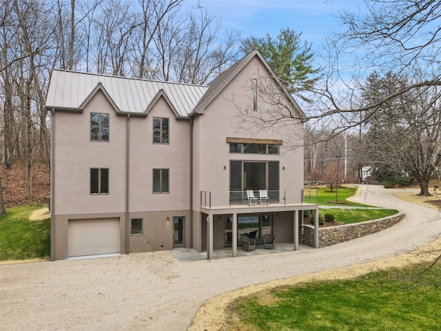 exterior space featuring a balcony, a front yard, and a garage