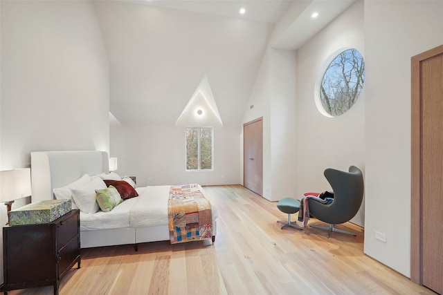 bedroom featuring light hardwood / wood-style flooring and high vaulted ceiling