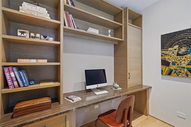 office area with built in desk and light hardwood / wood-style floors