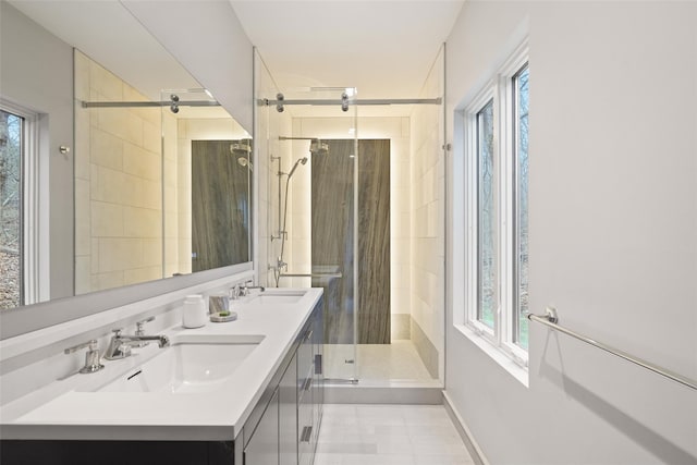 bathroom featuring tile patterned flooring, a tile shower, and vanity