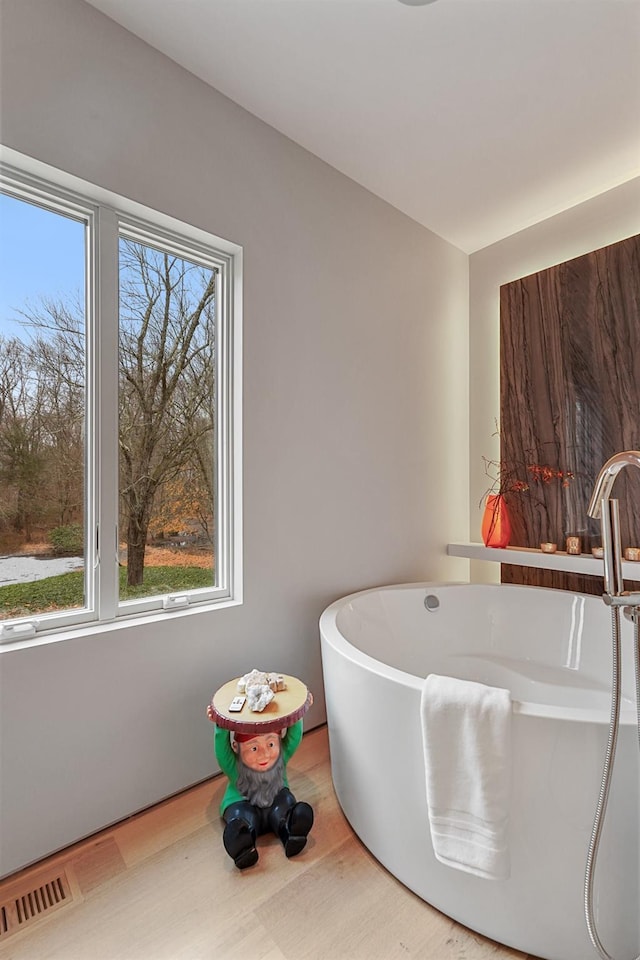 bathroom featuring a bathing tub, a healthy amount of sunlight, and sink