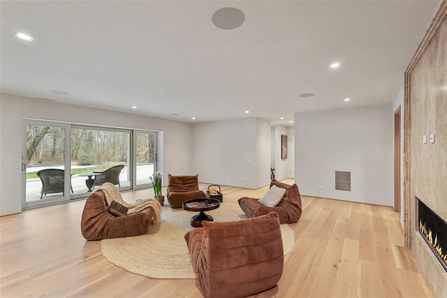 living room with a large fireplace and light hardwood / wood-style floors