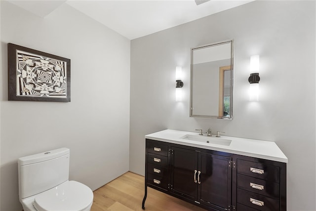 bathroom with hardwood / wood-style floors, vanity, and toilet