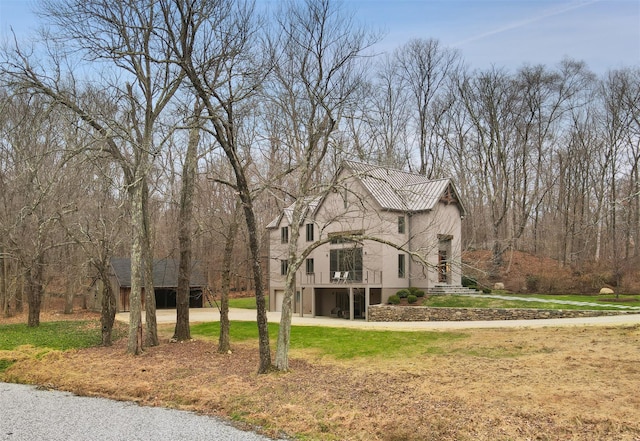 view of front of house with dirt driveway, a front yard, and stucco siding