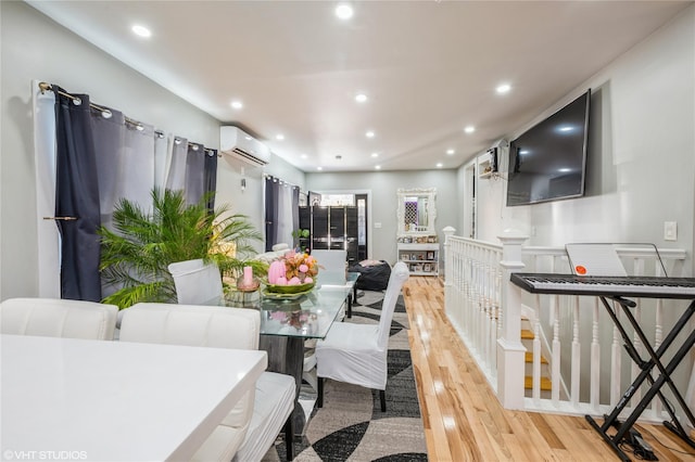 dining room featuring a wall unit AC and light hardwood / wood-style flooring