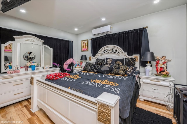 bedroom featuring an AC wall unit and light hardwood / wood-style flooring