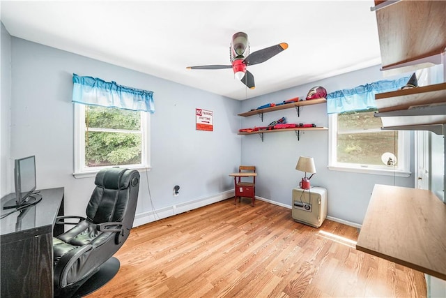 home office with light hardwood / wood-style flooring and ceiling fan