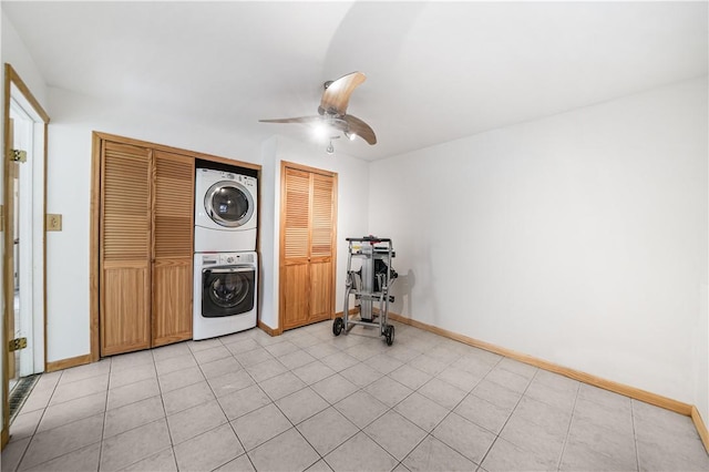 exercise room featuring ceiling fan and stacked washer / drying machine