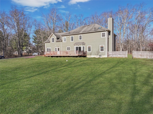 back of property with a deck and a yard