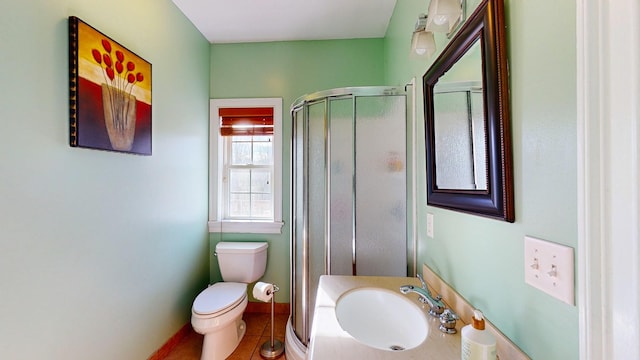 bathroom with walk in shower, toilet, sink, and tile patterned flooring