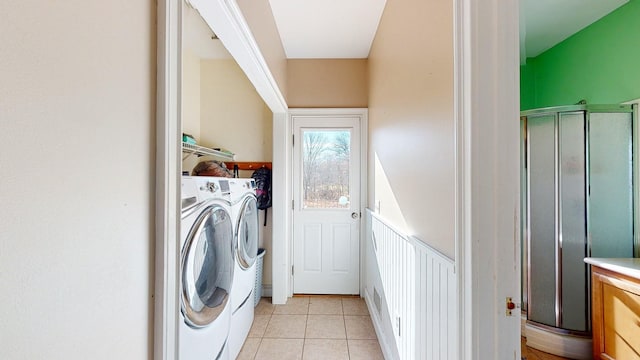 laundry room featuring washing machine and clothes dryer and light tile patterned floors